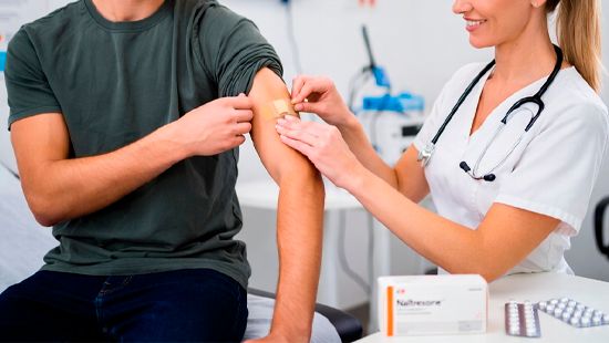 Медсестра наклеивает пластырь пациенту после укола